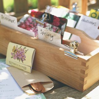 Seed packets in labelled wooden box in garden