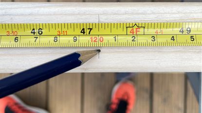 Yellow measuring tape close up with pencil to take measurement 
