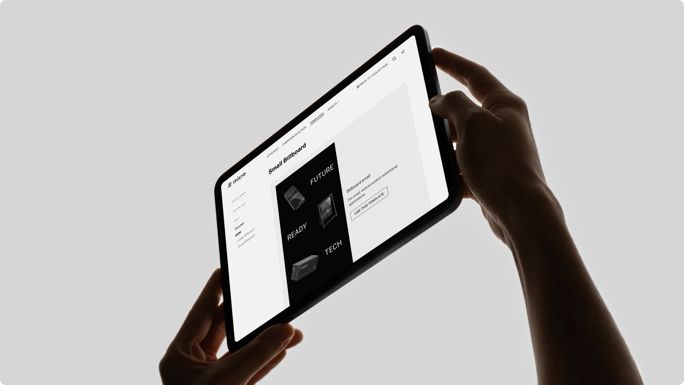 Frontify brand guidelines on an iPad held up by two hands