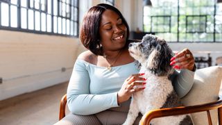 Woman sits with and fusses a dog