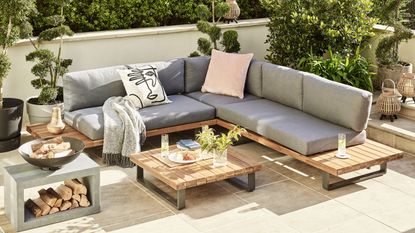A modern patio design with L-shaped grey outdoor sofa, with outdoor cushion decor and outdoor coffee table