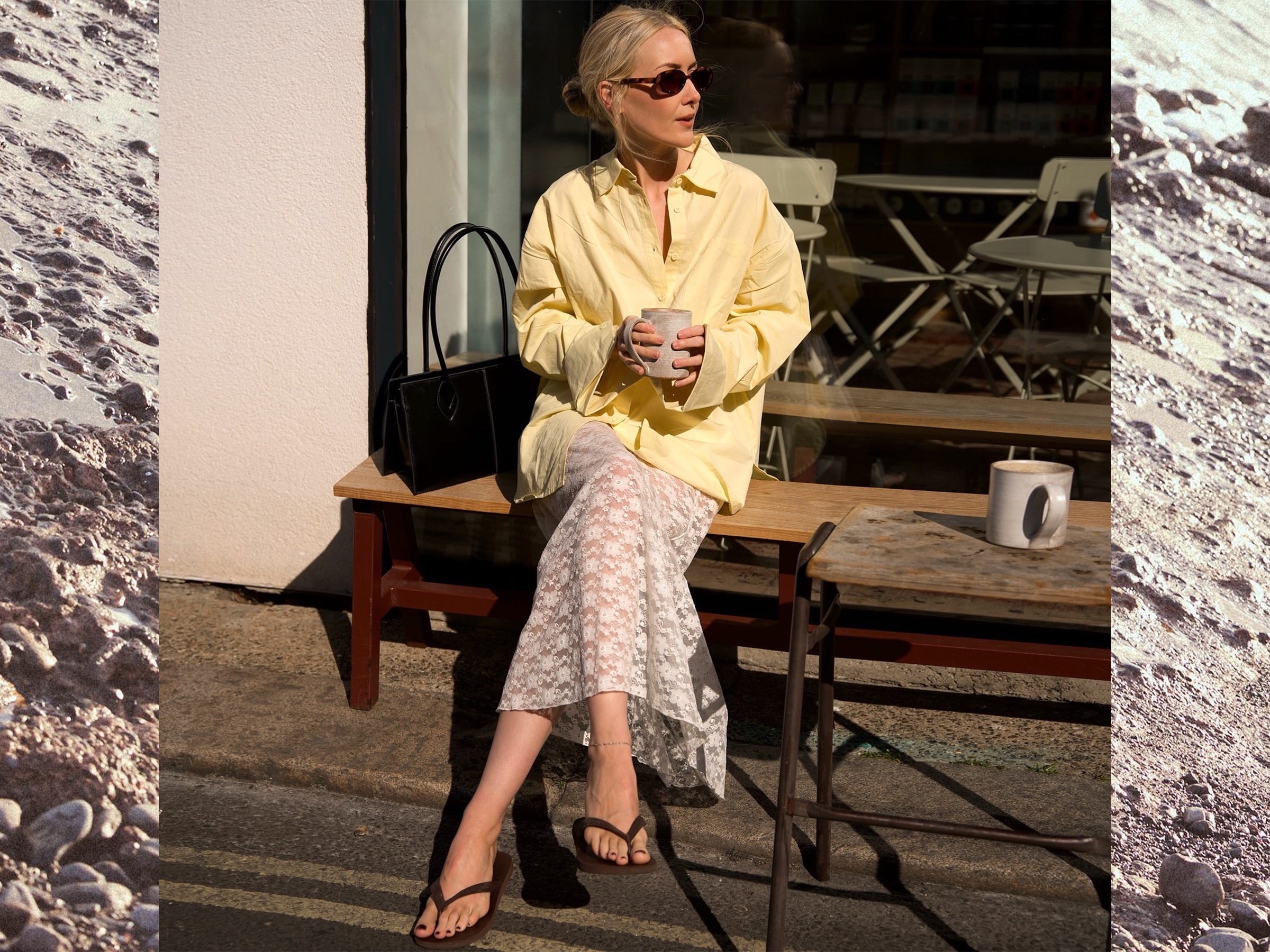 British influencer Chloe Butler sitting on a bench outside of a London cafe holding a mug of coffee while wearing oval sunglasses, a butter yellow button-down shirt, sheer white lace maxi skirt, a sleek shoulder bag, and brown flat flip-flop sandals