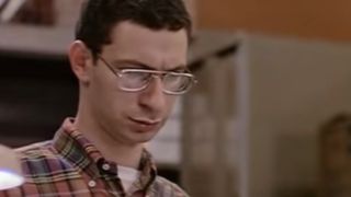 Eddie Deezen wearing glasses with a sour look on his face.
