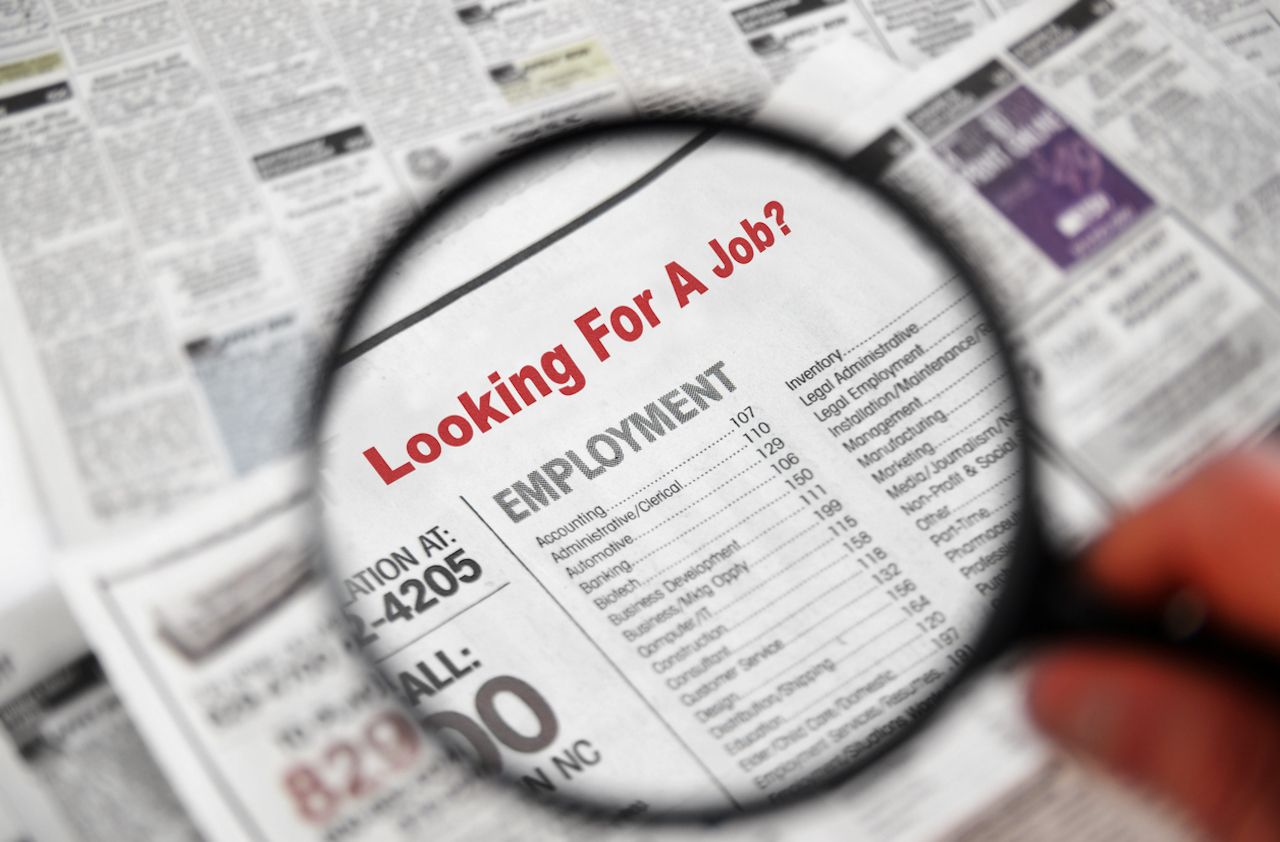 Magnifying glass over Jobs section of newspaper classifieds