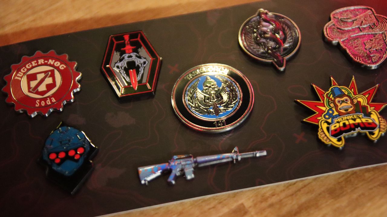 Call of Duty: Modern Warfare 3 Collectors Box items include lithographic prints, a metallic poster, and enamel pins.