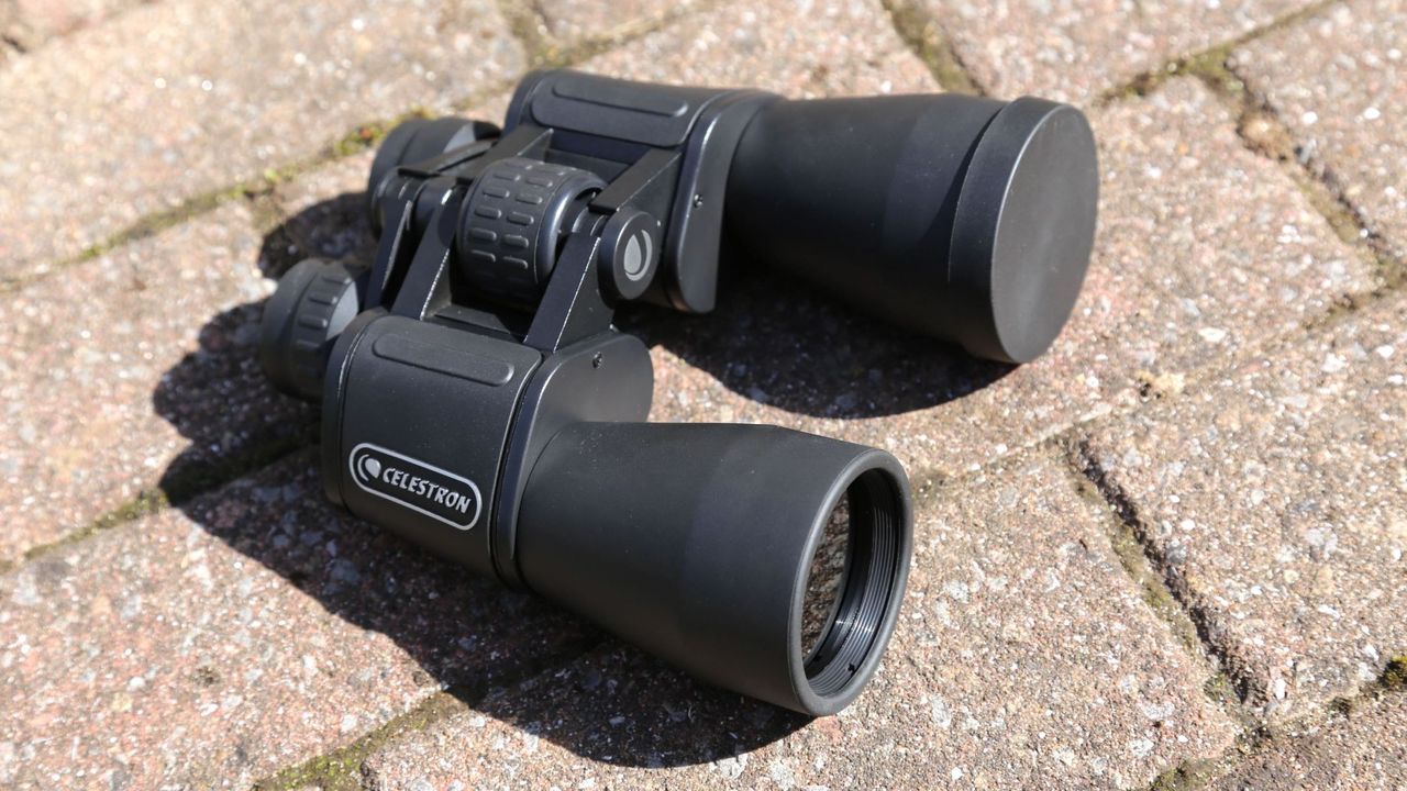 EclipSmart 12x50 binoculars placed on a stone surface