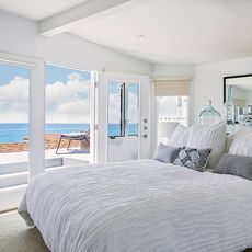white bedroom with carpet flooring and sea view