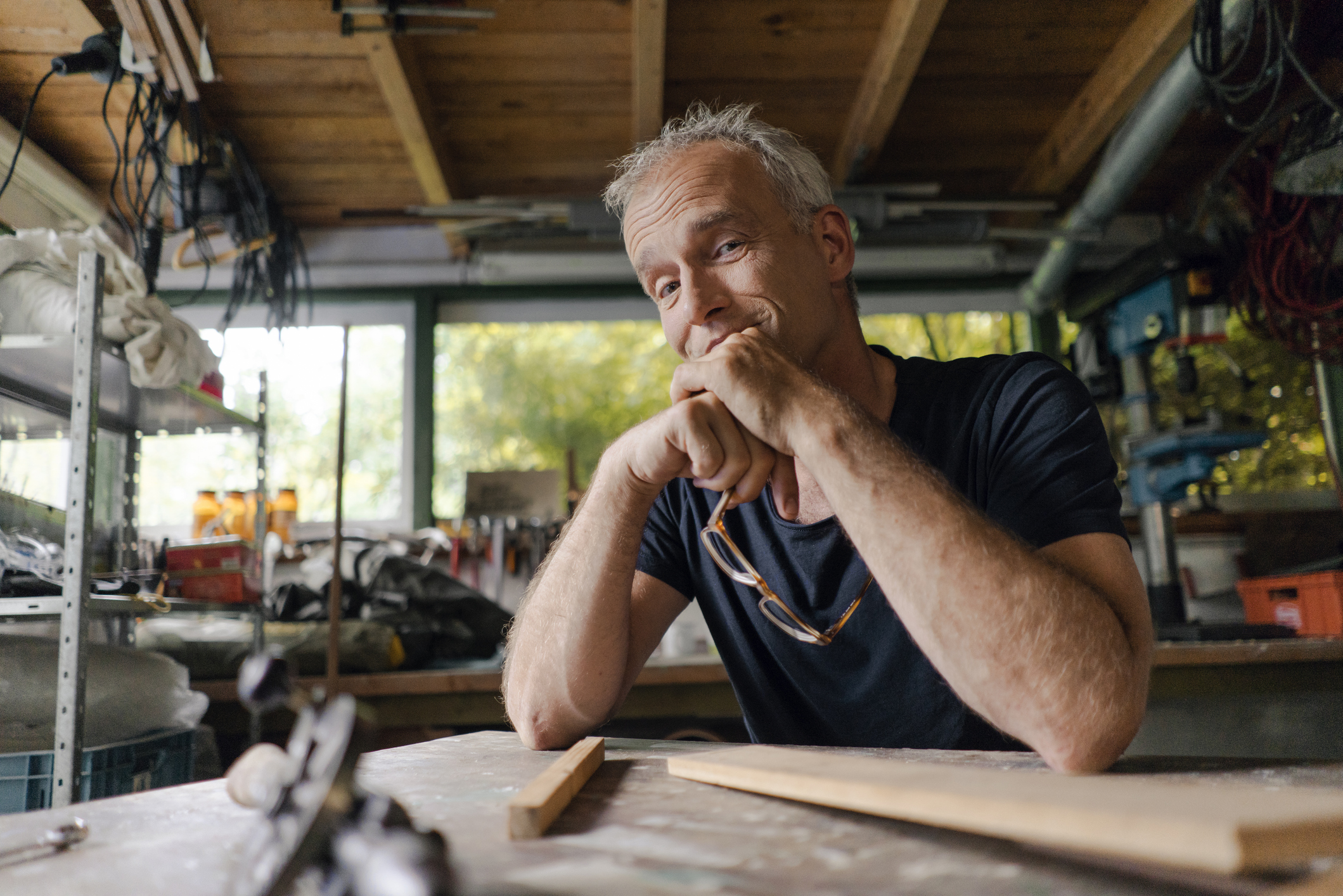 Portrait of confident mature man at workbench in his workshop.