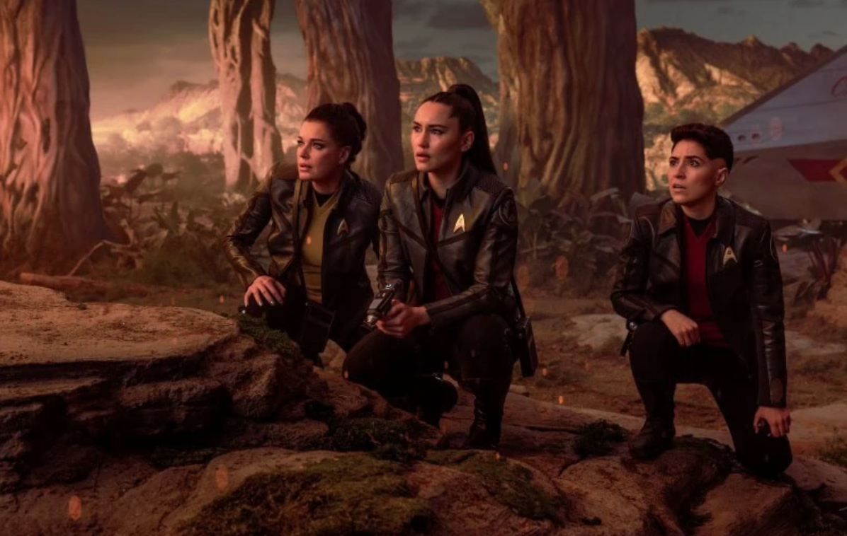 three crouching women on an alien planet