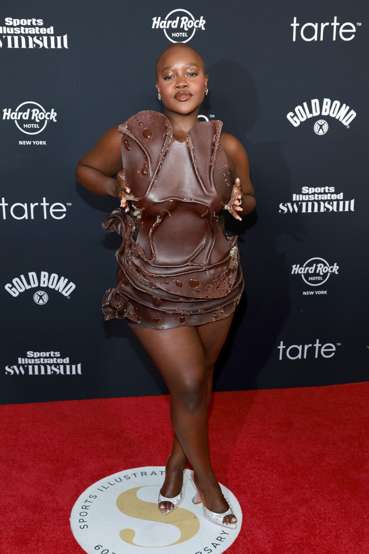 Achieng Agutu wearing a brown dress that looks like its made of water at the Sports Illustrated Swimsuit 2024 Issue Release and 60th Anniversary Celebration at Hard Rock Hotel New York.