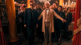David Tennant and Michael Sheen stand in front of a shop full of humans in Good Omens 2.