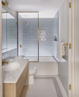 white bathroom with bath shower and blue tiles