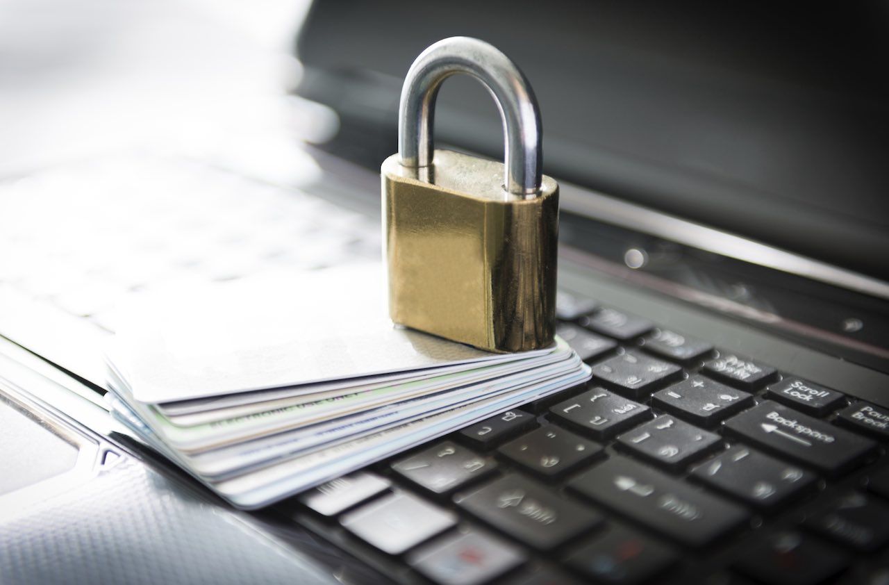 Padlock and credit cards on top of laptop