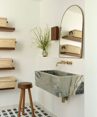 marble basin with white walls and black and white floor tiles