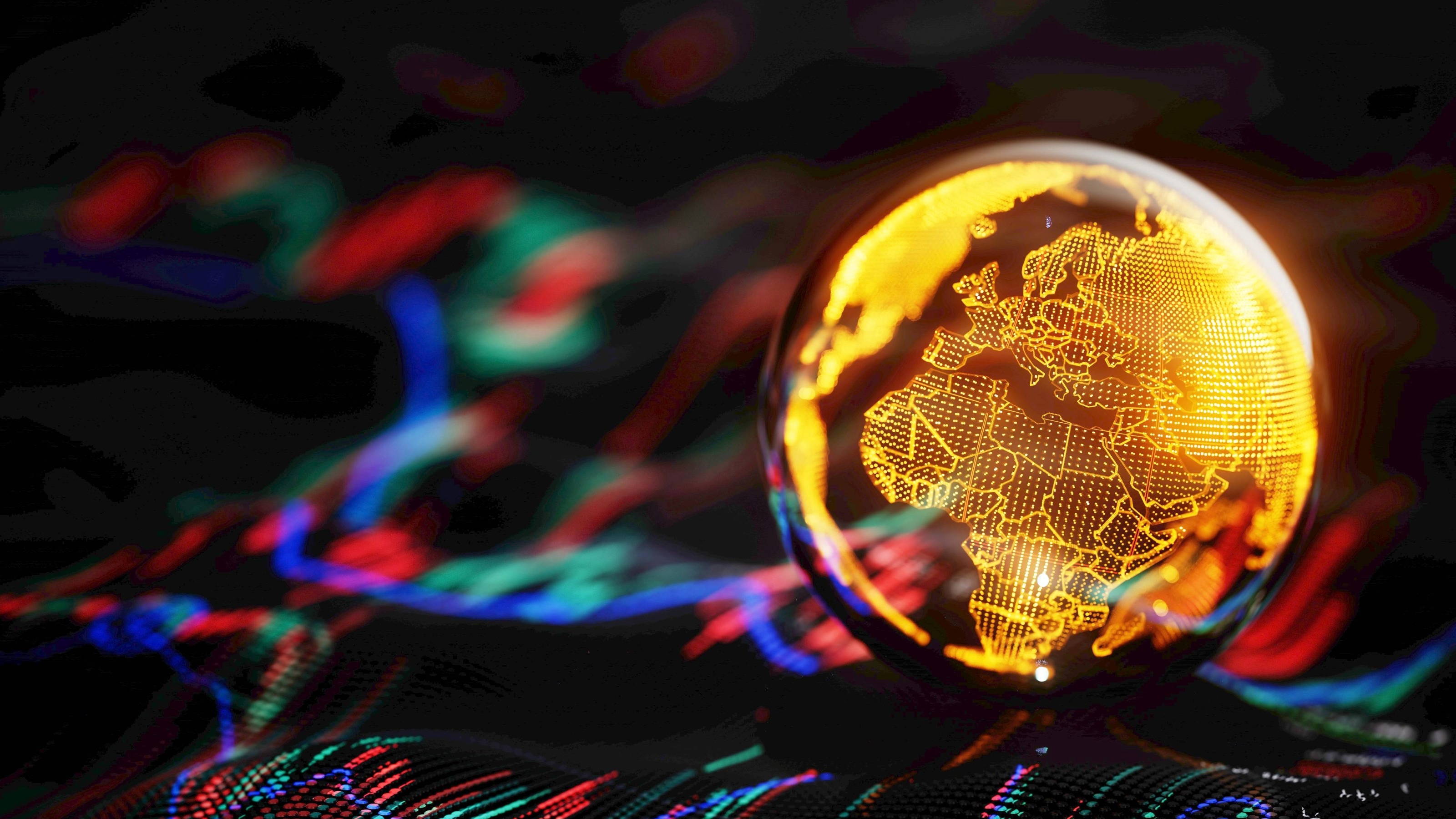A gold globe showing Europe and Africa sits on top of a stock chart