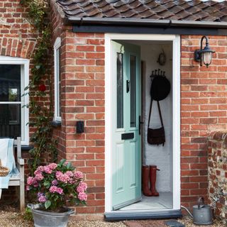 red brick house with blue front door opening into porch area