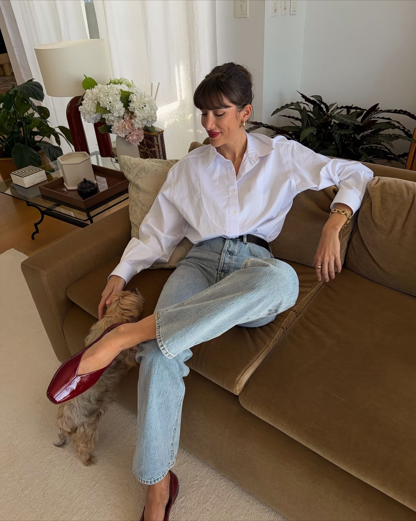 French influencer wearing a white button-down shirt with jeans