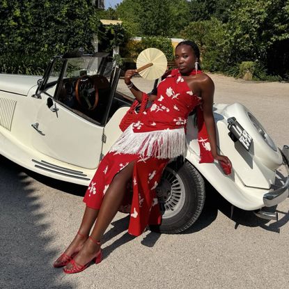 woman wearing red dress with white flowers and red heeled sandals