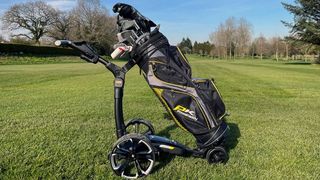 The PowaKaddy RX1 GPS Electric Trolley resting on the golf course with its bag