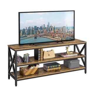 A TV on a wood and iron TV stand with decor on it