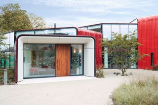 Maggie centre entrance view with large windows and red clad roof