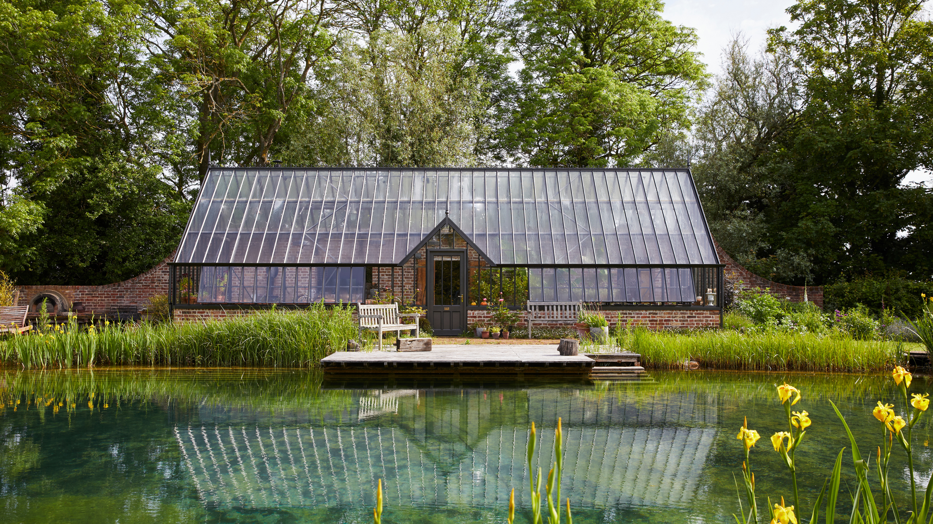 beautiful large greenhouse positioned across from a moat