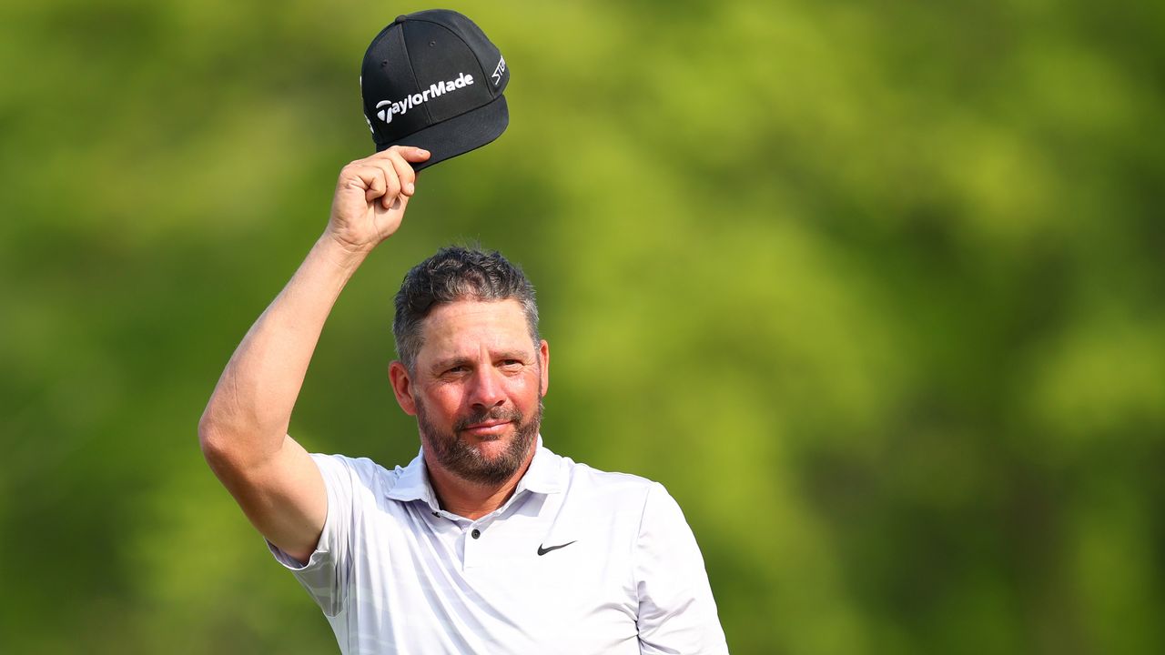 Michael Block takes off his cap and celebrates making a hole-in-one