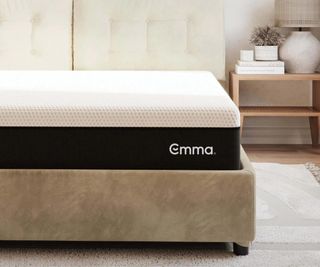 The corner of an Emma mattress on a bed.