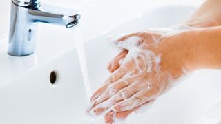 Person washing their hands.