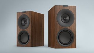 KEF Q Concerto Meta standmount speakers in wood finish against light grey background