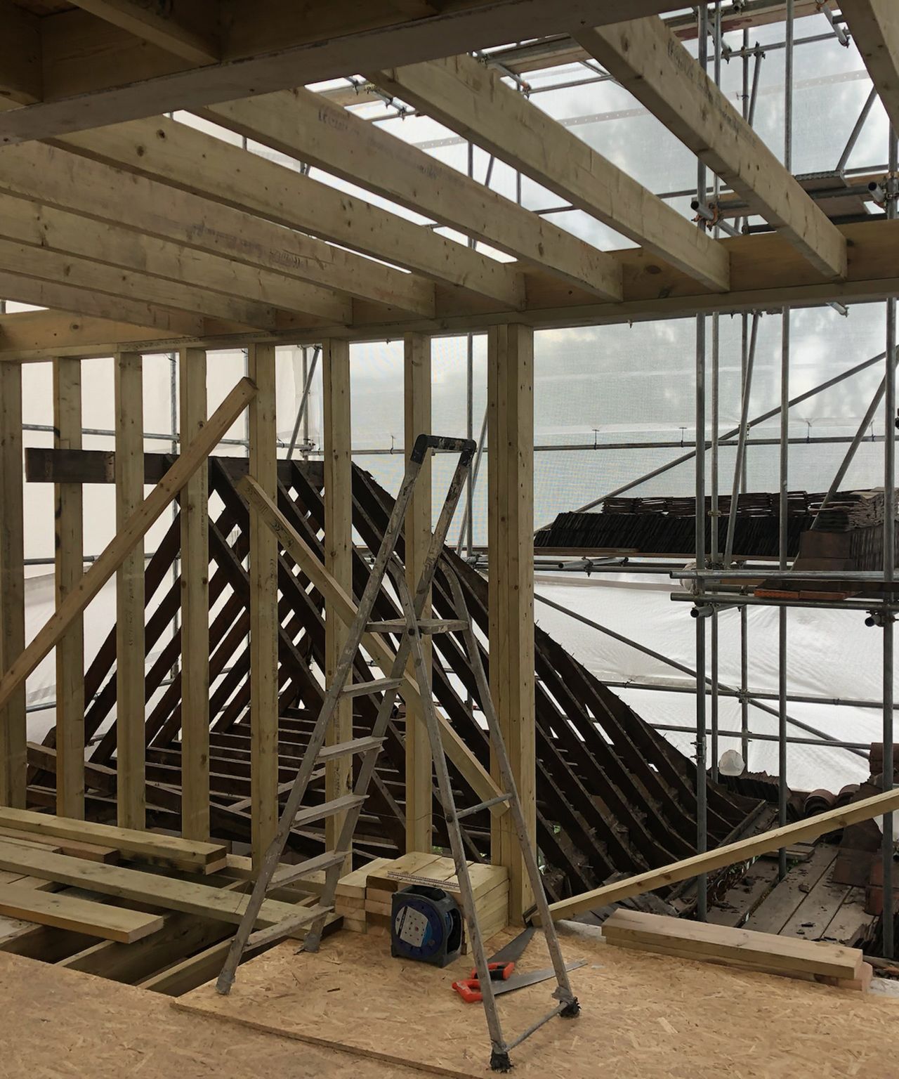 A loft extension with beams and chipboard flooring