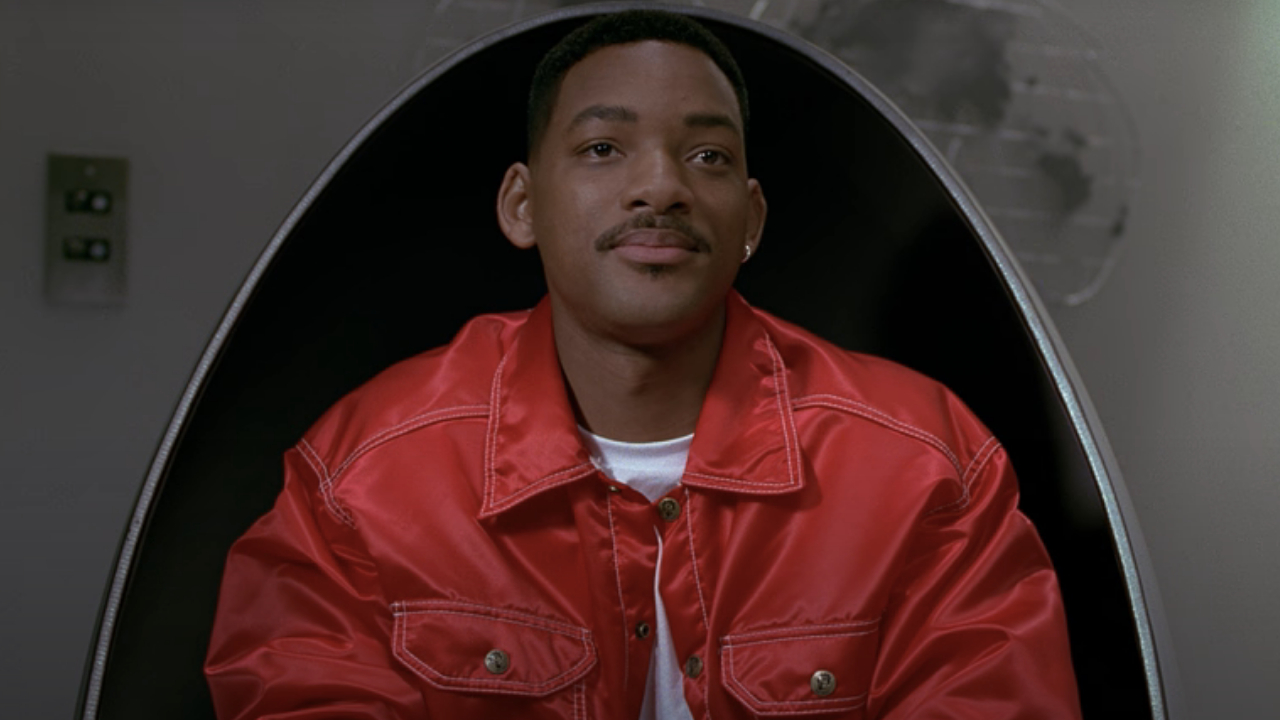 Will Smith sits in an egg shaped chair looking concerned in Men In Black.