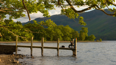 Fishing off Barrow bay jetty on derwentwater Keswick Lake District Cumbria.