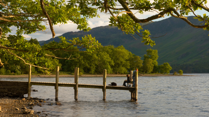 Fishing off Barrow bay jetty on derwentwater Keswick Lake District Cumbria.