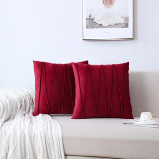 Two red throw pillows on a white couch