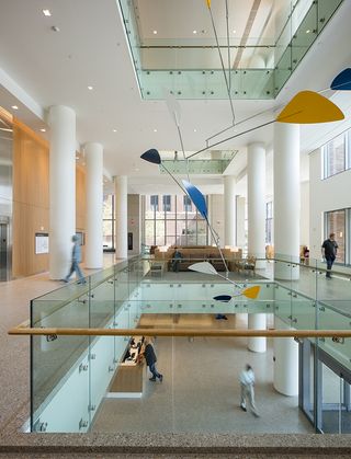 Central aspect of the hospital with white pillars, glass panelling and artwork