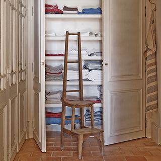 white cupboard with towels and wooden ladder