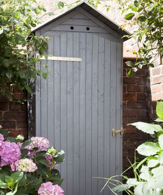 grey wooden shed in backyard for storage