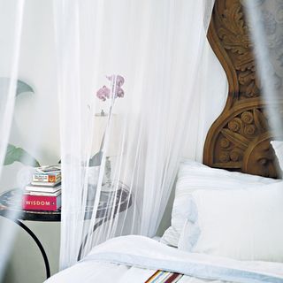 bedroom with mosquito net bedside table
