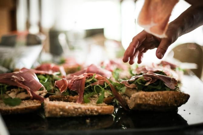 Amanda Shission applies prosciutto to the team sandwiches