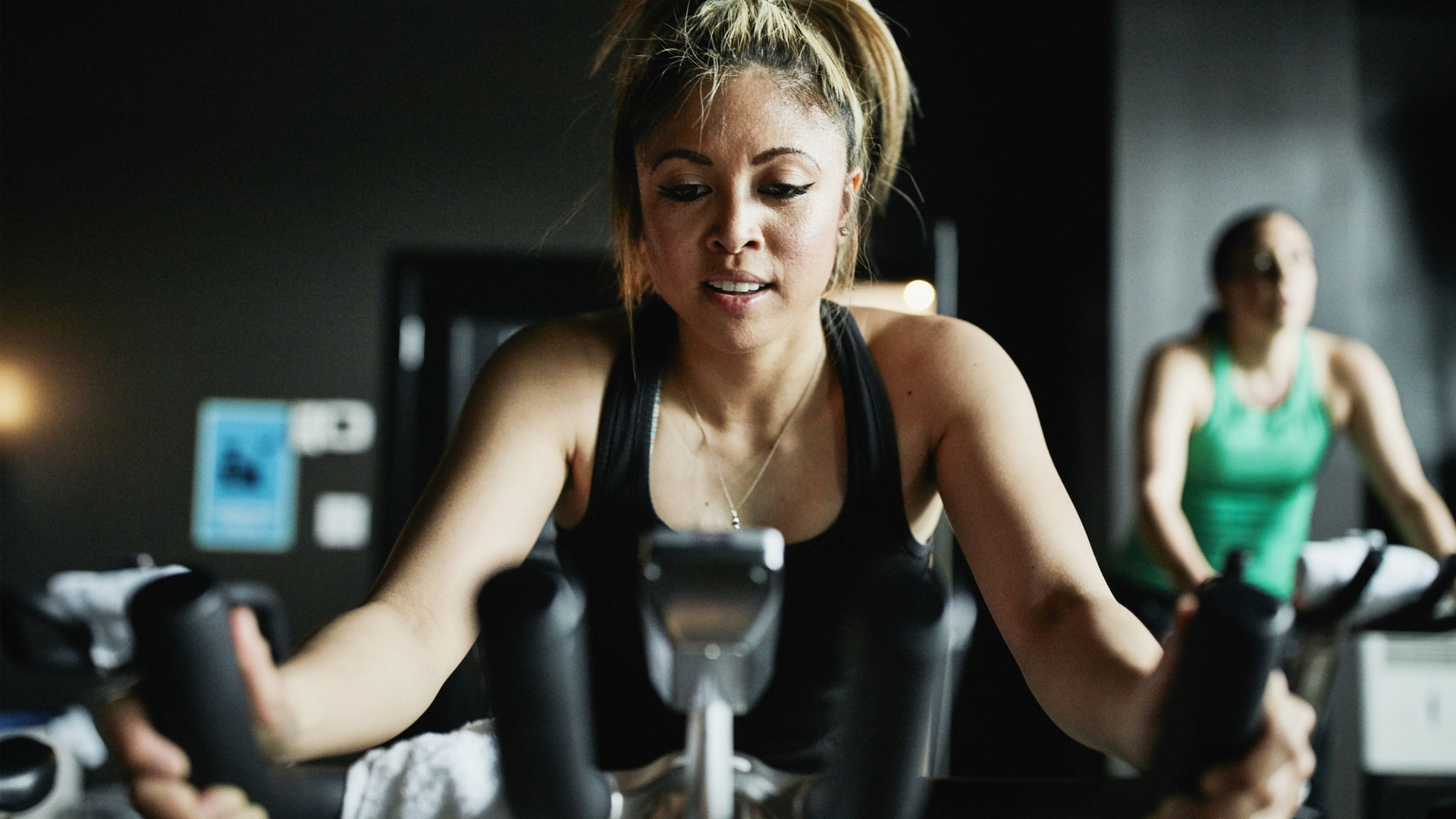 how to lose weight using an exercise bike: image shows woman on exercise bike at gym
