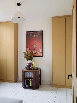 Soft yellow built-in wardrobes in a white bedroom
