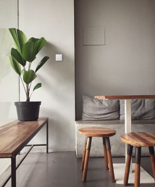 dining area with bench, wooden stools and slim thermostat panel on wall