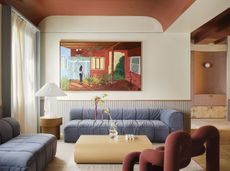 a modern living room design featuring a blue sofa, red vaulted ceiling and neutral walls