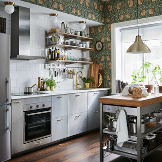 brushed stainless steel kitchen with handles, open shelving and floral wallpaper by Ikea