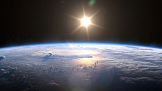 the sun rises above earth as seen from space
