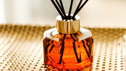 best reed diffusers: a reed diffuser on a gold table