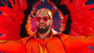 Seth Rollins comes out with an orange outfit and orange headgear.