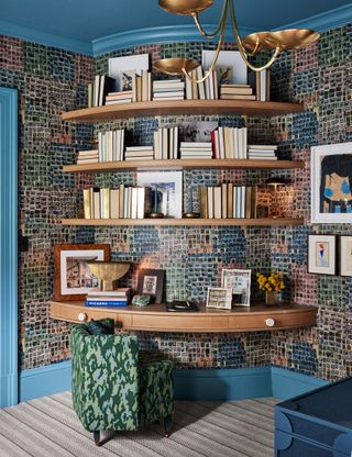 A room with colorful wallpaper and bookshelves wrapped around a curved corner