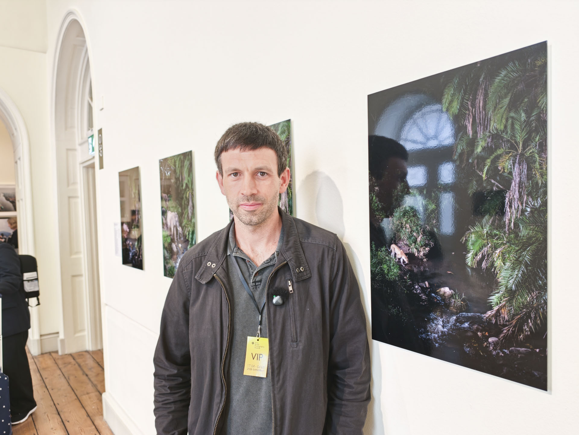 Wildlife photographer Will Burrard-Lucas standing by his SWPA 2026-winning images at the contest's exhibition in Somerset House, London